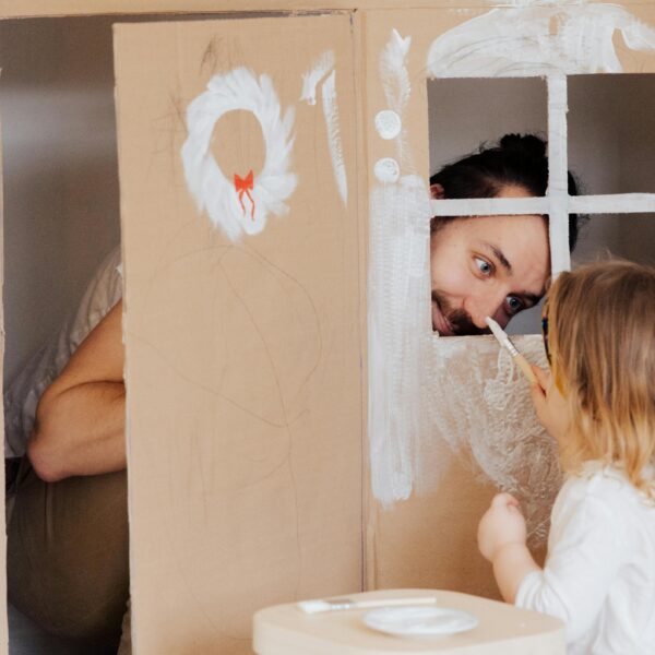 A Little Girl and her Dad Painting a Cardboard House