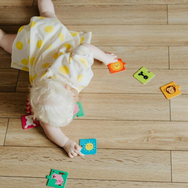 A Toddler Playing with Puzzle Pieces on the Floor